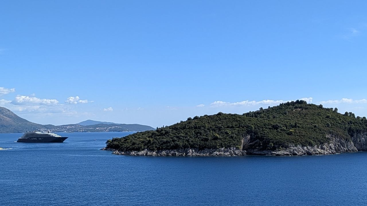 Šumovito ostrvo ispred dubrovačke obale i veliki putnički brod.