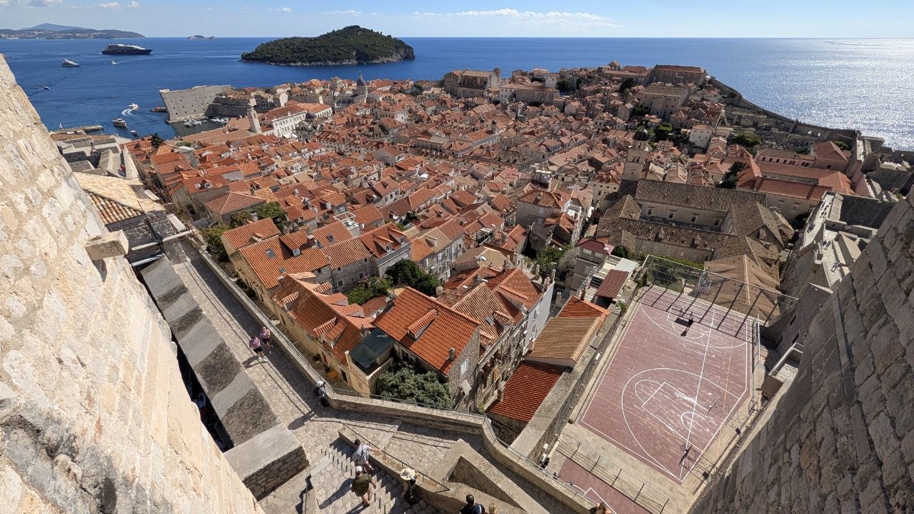Panoramski pogled na Stari grad Dubrovnik, crvene krovove i Jadransko more s gradskih zidina