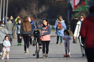 Ljudi šetaju na otvorenom po sunčanom vremenu.