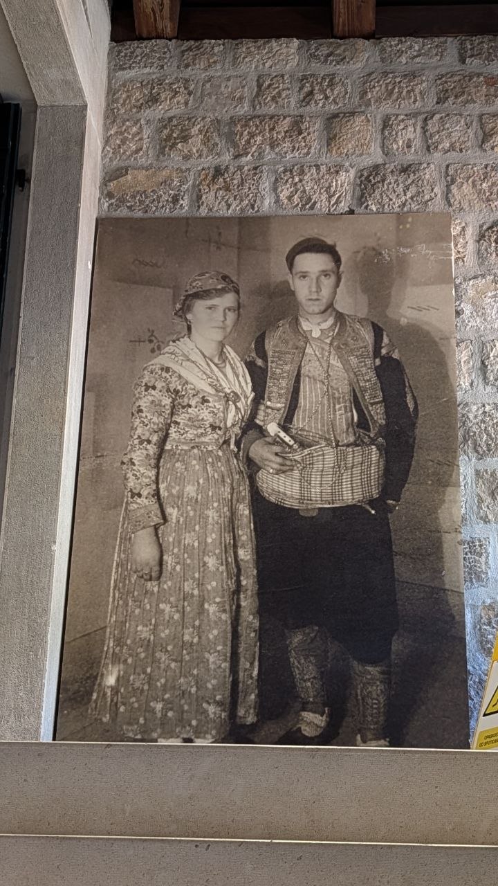 Arhivska fotografija para u narodnoj nošnji u etnografskoj postavci.