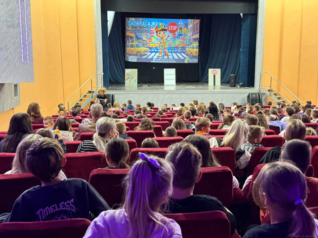 Djeca i odrasli gledaju projekciju o sigurnosti u saobraćaju tokom predstave u Kino-sali