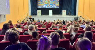 Djeca i odrasli gledaju projekciju o sigurnosti u saobraćaju tokom predstave u Kino-sali