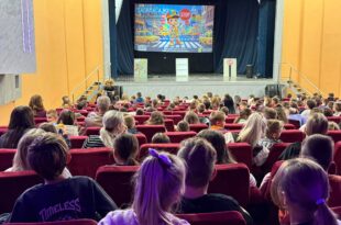Djeca i odrasli gledaju projekciju o sigurnosti u saobraćaju tokom predstave u Kino-sali