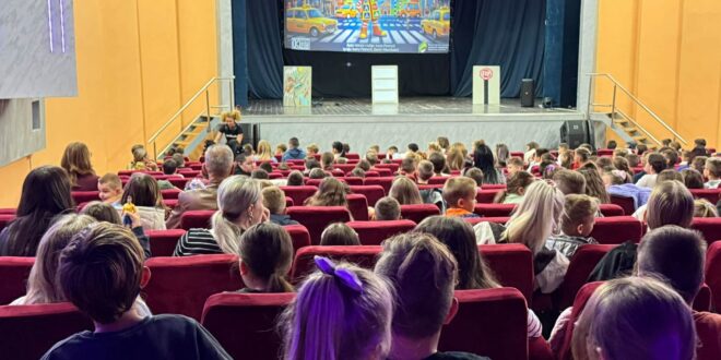 Djeca i odrasli gledaju projekciju o sigurnosti u saobraćaju tokom predstave u Kino-sali